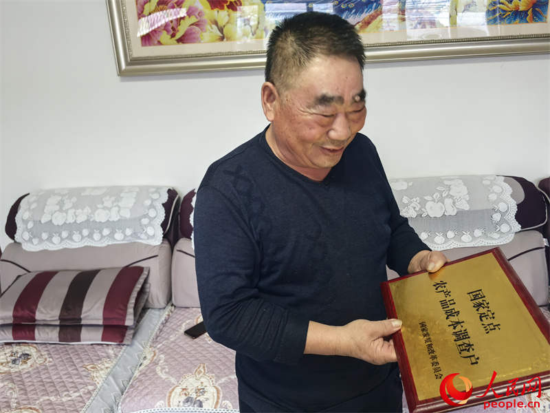 李強向記者展示他獲得的“國家定點農產品成本調查戶”牌匾。人民網記者 陳新輝攝