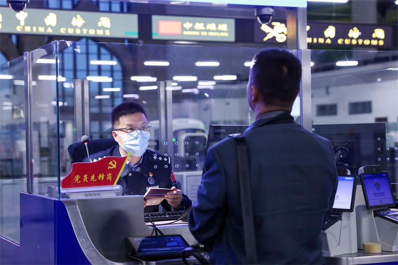 圖為霍爾果斯出入境邊防檢查站民警為入境游客辦理邊檢手續(xù)。宋唯一攝